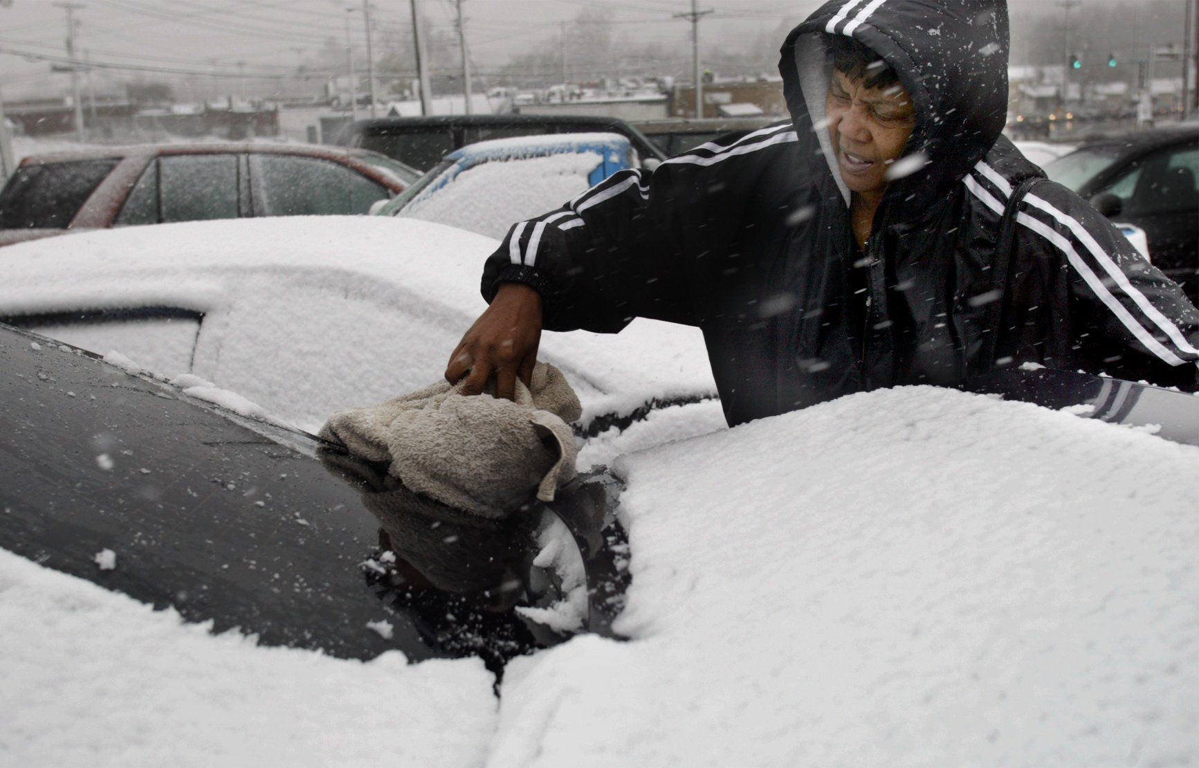 Woman scrapes snow from her car